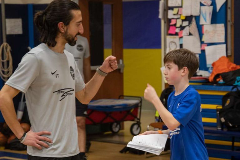 Tiempo coach high-fiving a young player